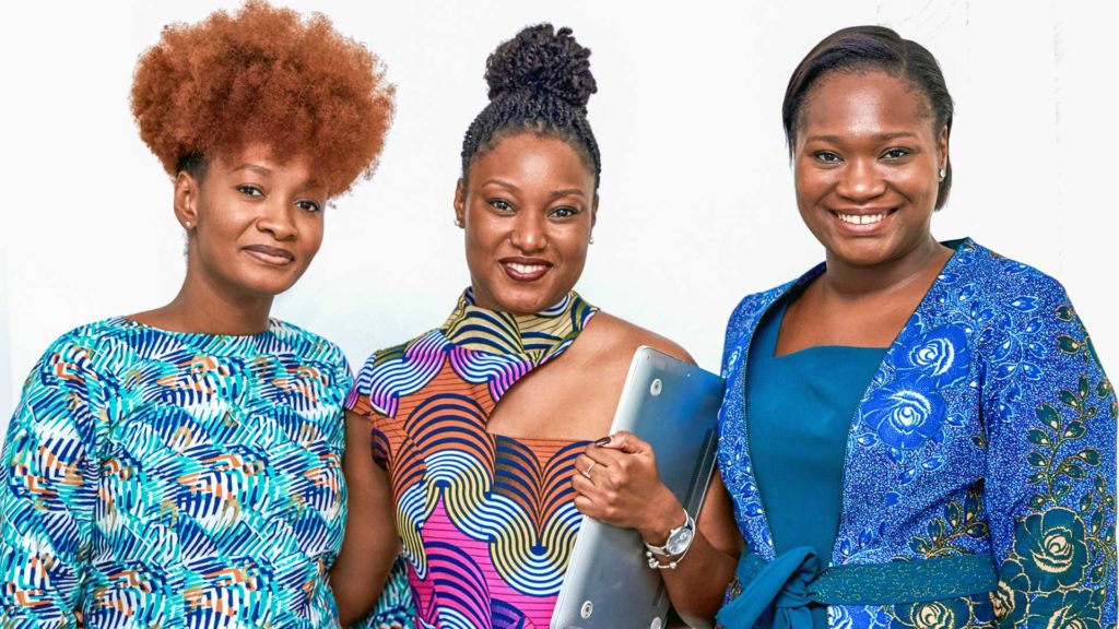 Three African women looking towards the camera smiling